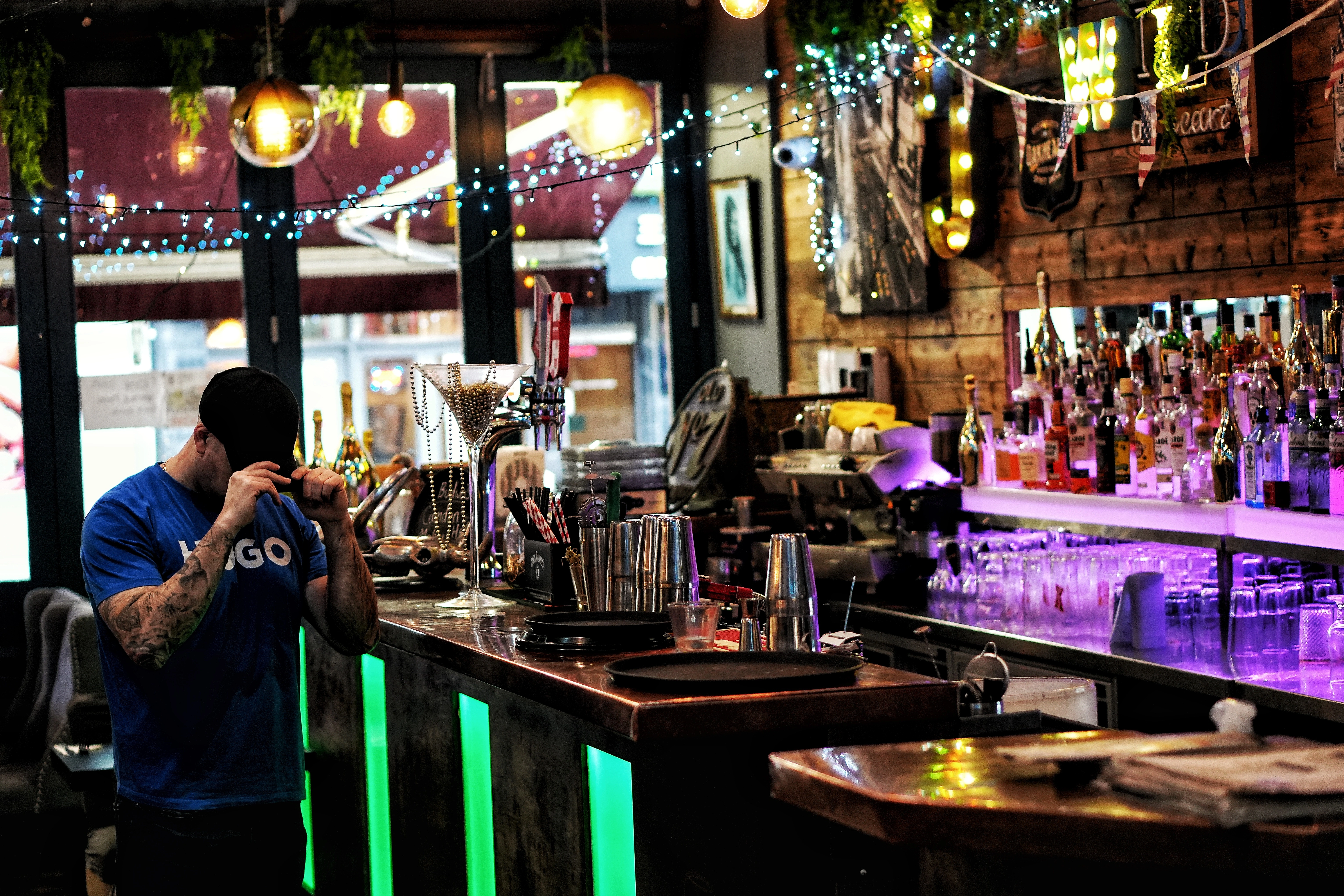 Smiling woman in white t-shirt holding a small tan poodle with pink bow