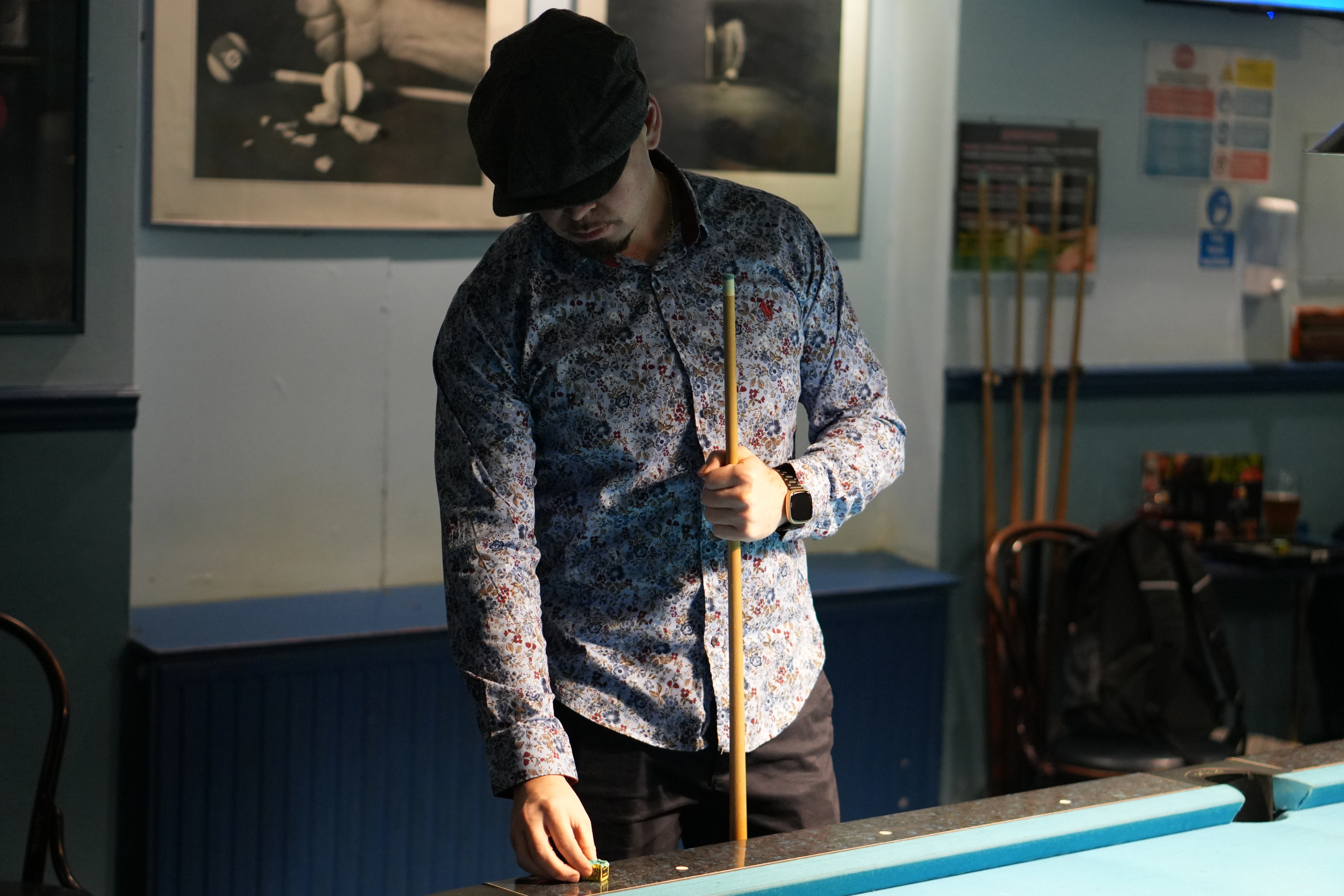 Seagull in flight over wooden pier with bright sun creating starburst effect above ocean