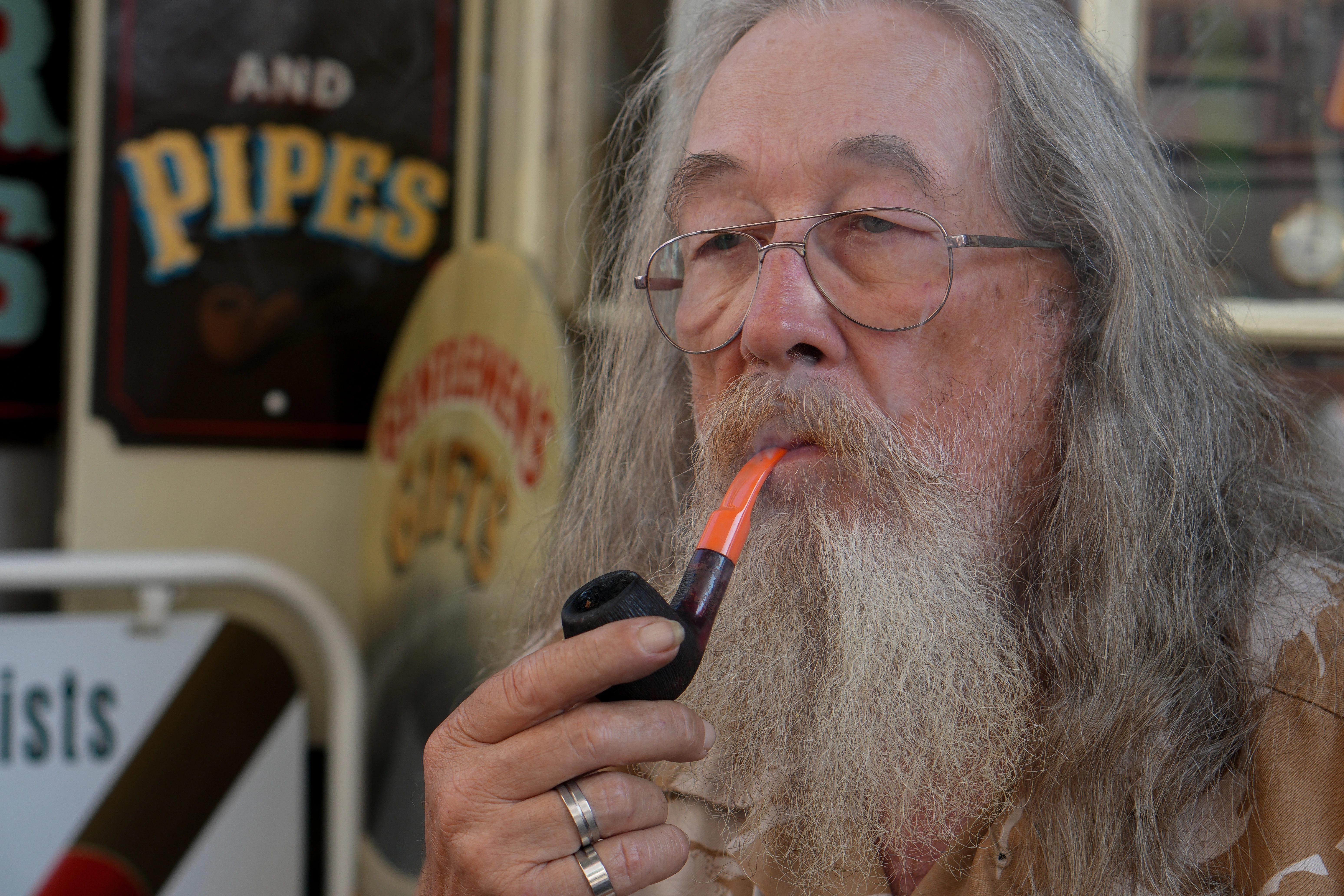 Lakeside train platform with vintage clock showing next train times and green hills in background